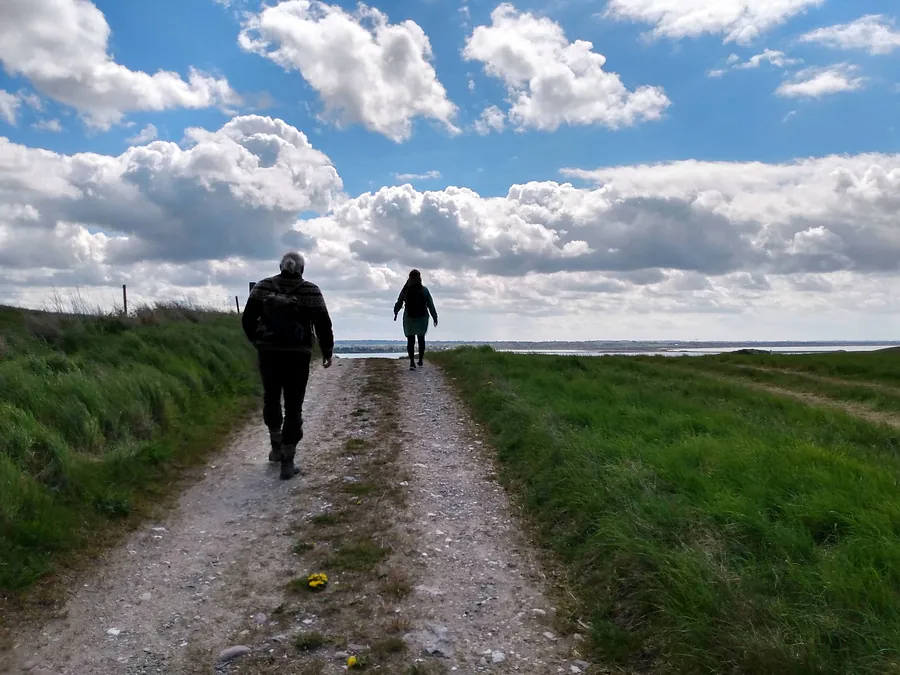 To personer på vandring ad en grussti under en sogneudflugt.