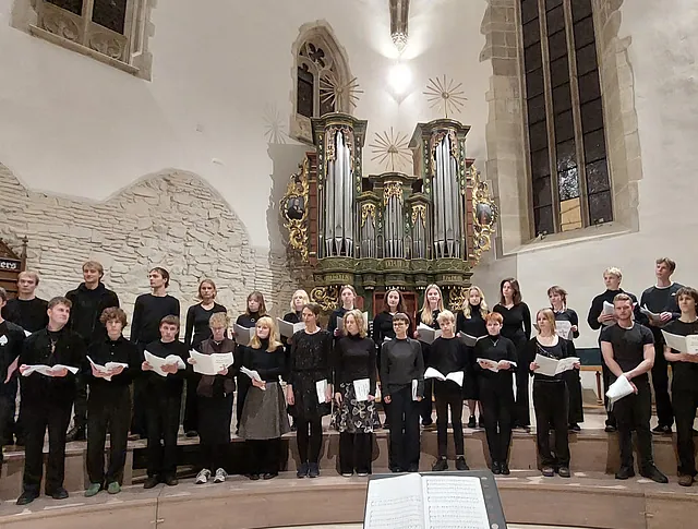 Ungdomskor i sort tøj opfører en koncert i Haslev Kirke.